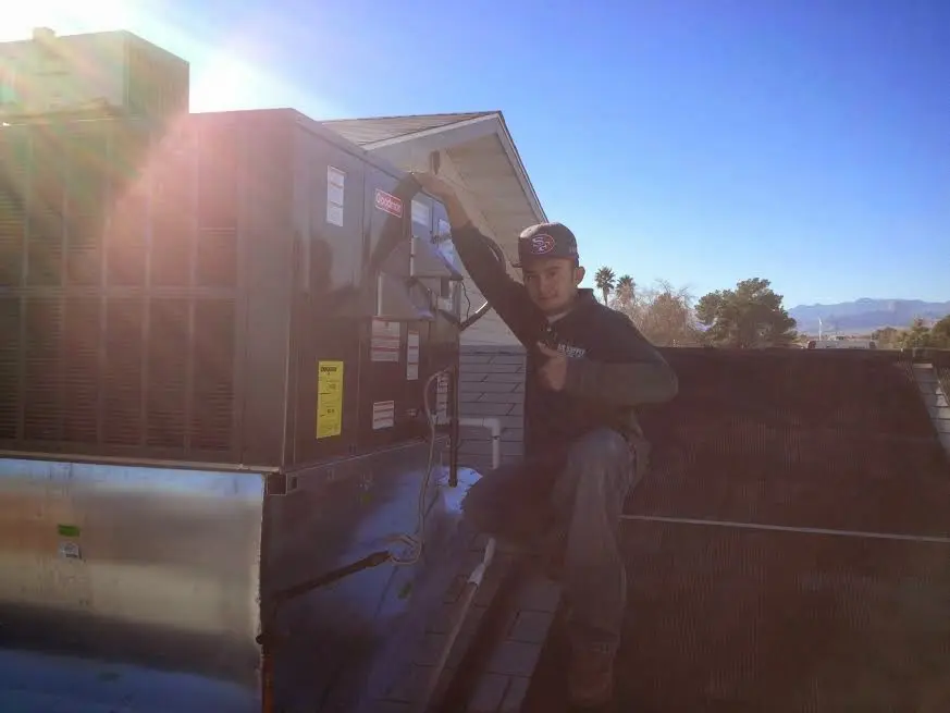 HVAC technician performing Air Duct Cleaning on a rooftop unit in Rostraver